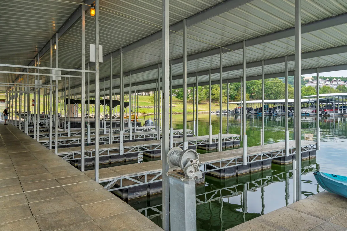 A peaceful scene of boat docks extending into calm lake waters, with metal framework visible and hints of sunset colors. Activities like boating, fishing, and relaxing by the water are suggested, evoking the tranquility and adventure of lakeside living.