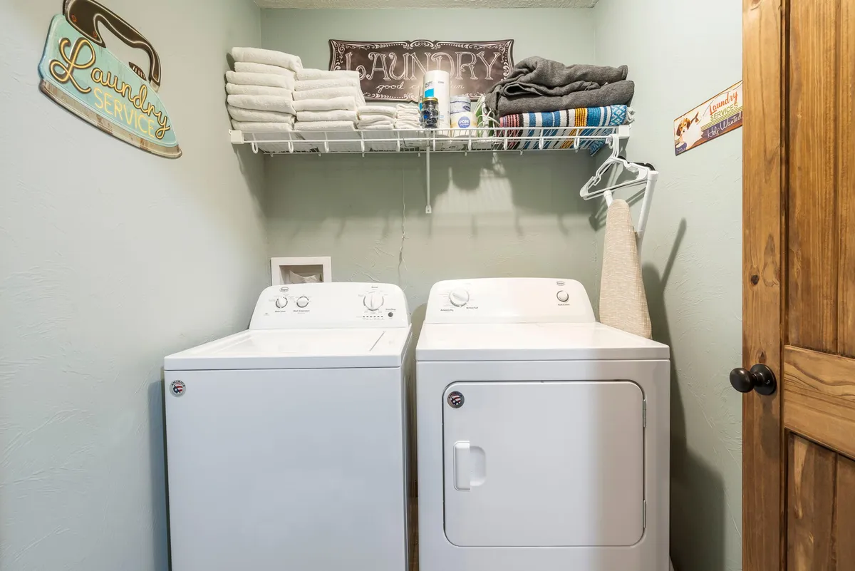 A well-organized laundry area with a washing machine, dryer, and neatly folded towels. The space is practical and clean, ready for guests to use during their stay.